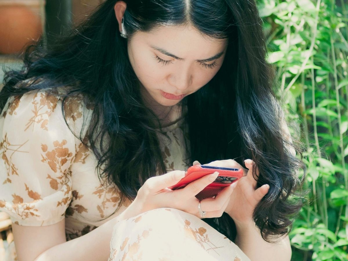 Young Asian Woman Texting On Cell Phone